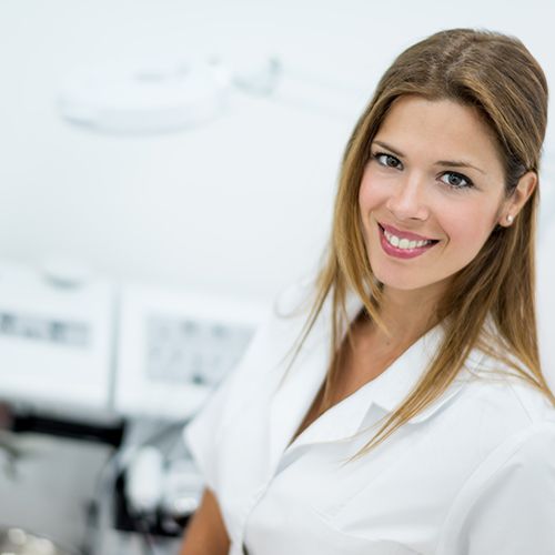 Female esthetician standing beside various treatment machines.